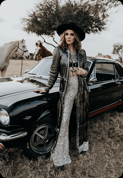 Model posing with a classic car during a style shoot